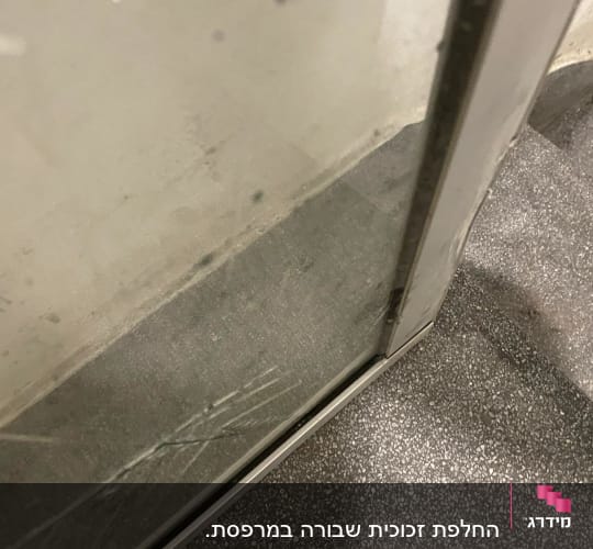 זכוכית עם שריטות במסגרת מתכת ליד מדרגות